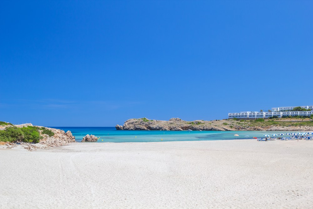 Playa Arenal de Son Saura con arena blanca en la isla de Menorca, España.