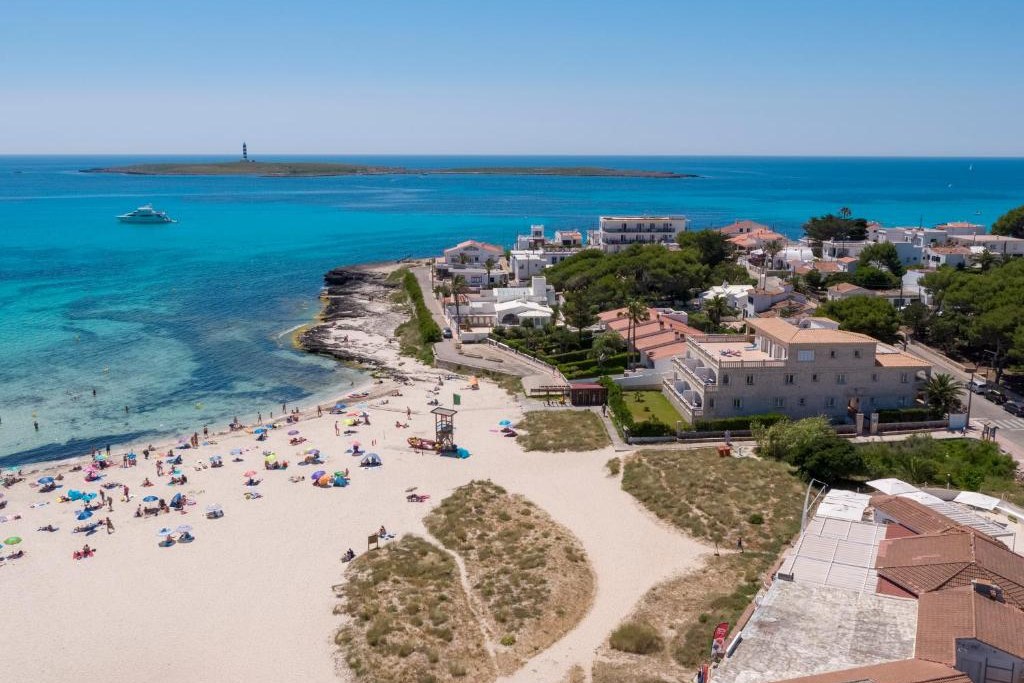 La spiaggia di Punta Prima, a Minorca, vista dall'alto con l'Illa de l'Aire sullo sfondo