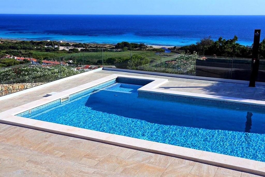 La piscina di Villa Ona con il mare di Son Bou sullo sfondo, a Torre Solí Nou, Minorca